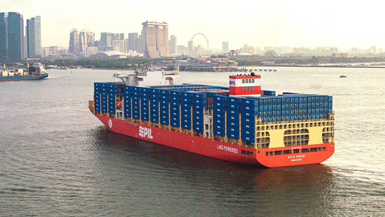 Red container ship stacked with blue containers