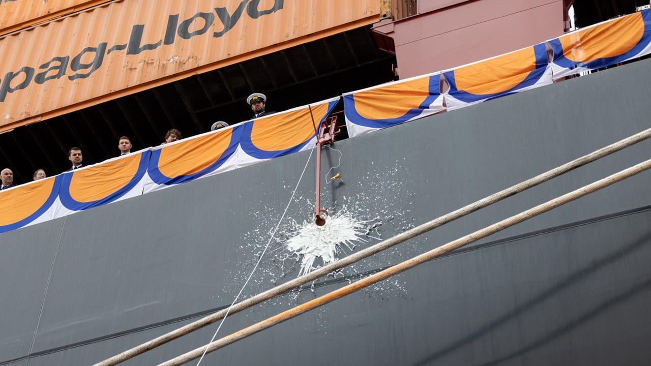 champagne bottle being smashed on ship's hull