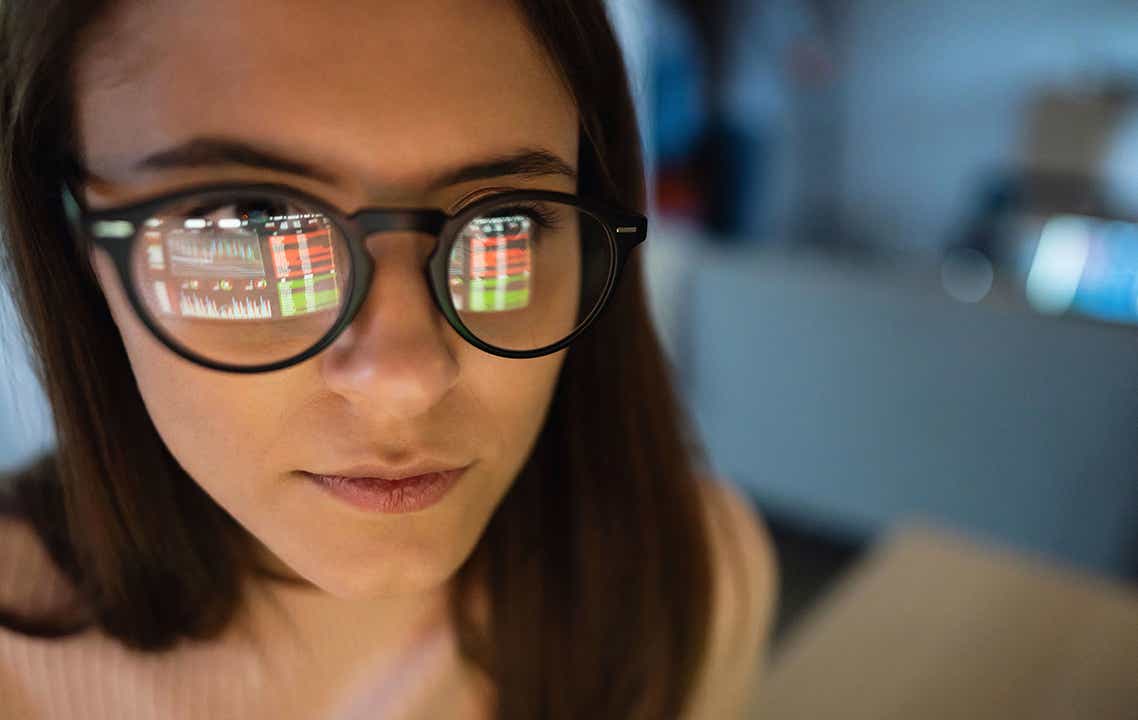 Spiegelung eines Datenmonitors in der Brille eine jungen Frau. 