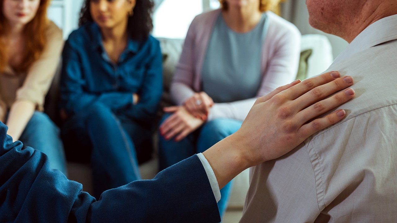 Menschen in einem Gesprächskreis, die sich gegenseitig unterstützen.