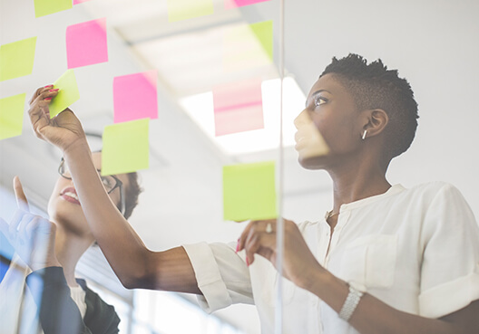 What's in it for you? Woman sticking post-it notes on a wall