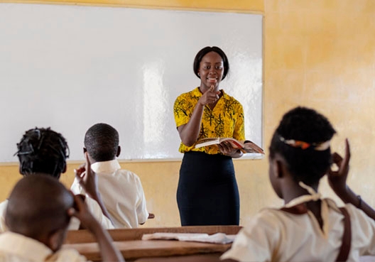 Teacher standing in front of her classroom teaching her students Teacher standing in front of her classroom teaching her students