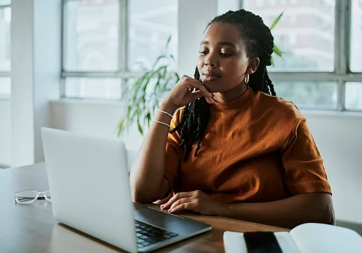 Young professional looking at her loan options on her laptop Young professional looking at her loan options on her laptop