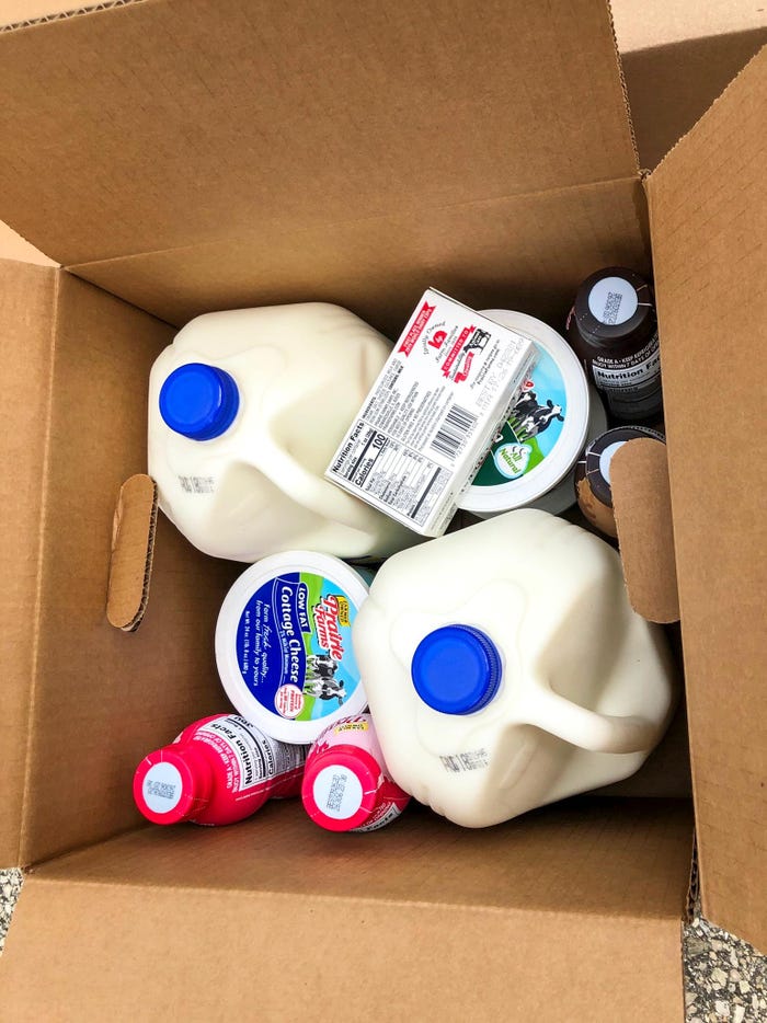 A cardboard box filled with various dairy products