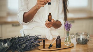 A woman holding a bottle of lavender oil