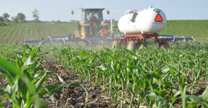 tractor pulling tank applying sidedress in cornfield