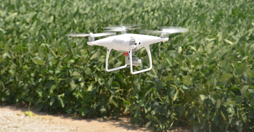 white drone flying over soybeans