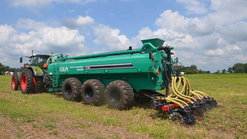 A tractor and manure applicator injecting manure as fertilizer in a field