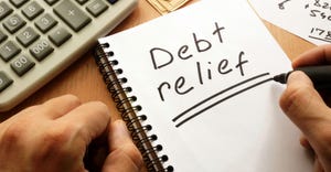 Note with words debt relief written on a tablet