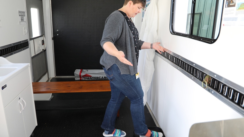 Cory Bromfield demonstrates the biosecurity trailer between the “dirty” and “clean” sides at the MU Beef Farm