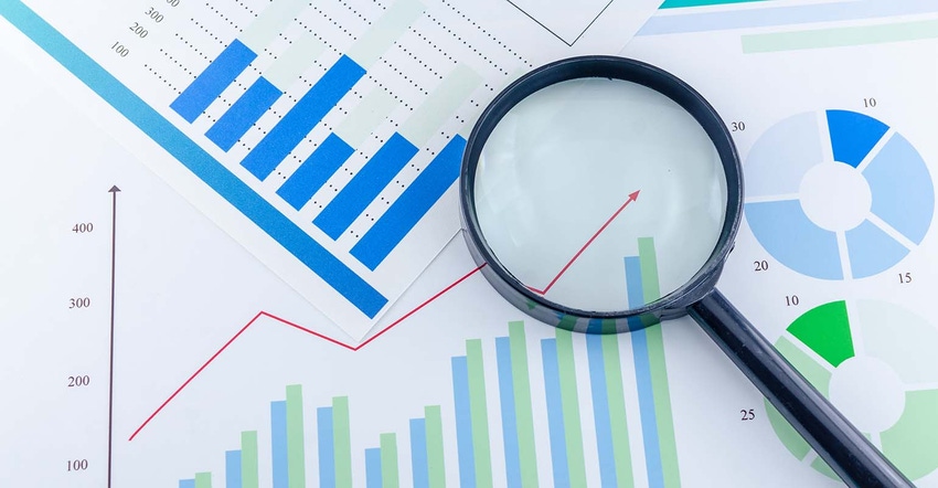 Magnified glass looking at financial reports 