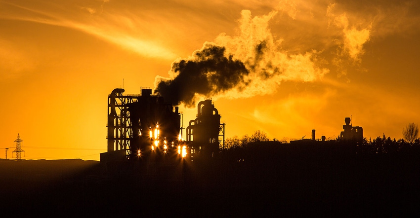 Manufacturing facility silhouetted against sunset