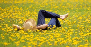 woman lying in field of yellow flowers
