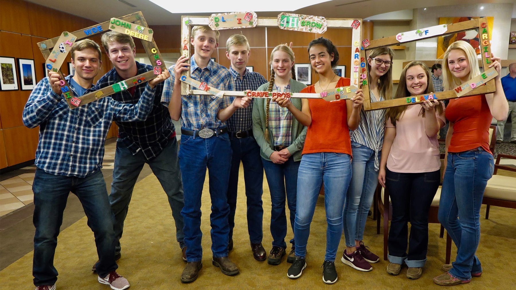 group of teenagers holding up crafted photo frames