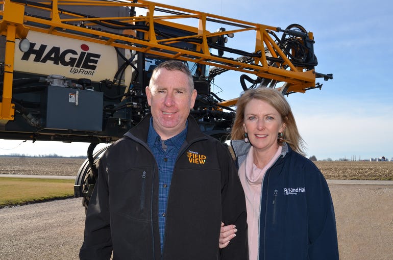 Doug and Christy Aylward pose in front of crop sprayer
