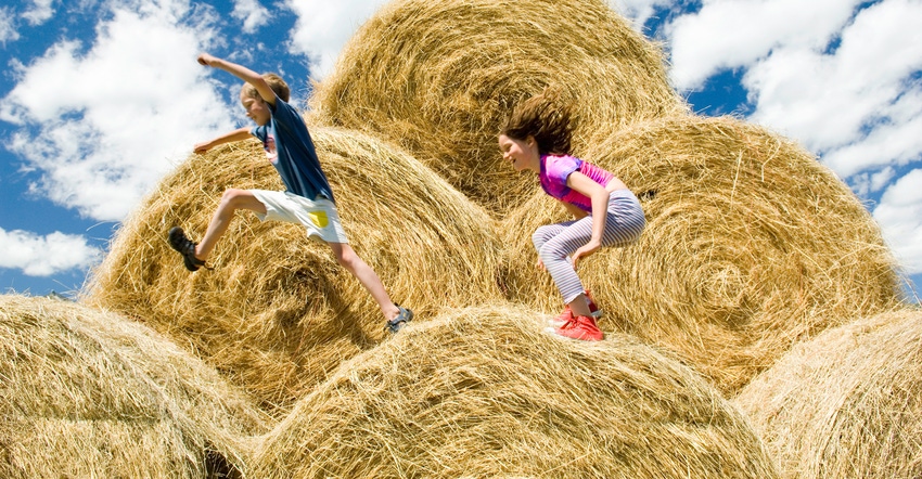 Children jumping on hay bales