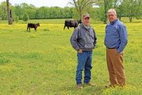 RANDY CURTIS, 2001 Brangus Herdsman of the Year, stands with Pat Woods on pasture for some of Pat’s cow/calf herd. (Photo by Brad Robb) Click to enlarge