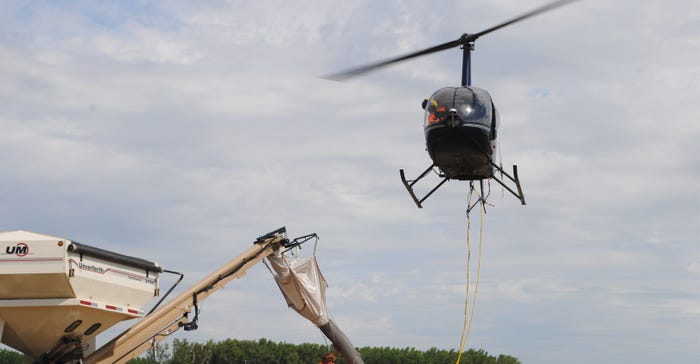 Brent Wulf, owner and operator of Hexagon Helicopters based in Bennington, Neb., hovers overhead while his ground crew, Taylo