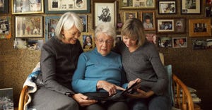 Three generations of women looking at photo album