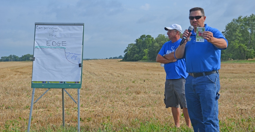 Jared Chew speaking at field day as Mike Starkey watches behind him