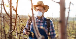 Farmer protecting his field with chemicals wearing a mask