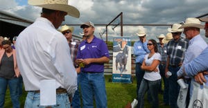Attendees at a Kansas Livestock Association field day gather around to hear from Brandon Depenbusch, CattleTrace board chairm