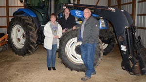 Ohio Master Farmer Tim Norris standing by tractor with wife Heidi and son Eli