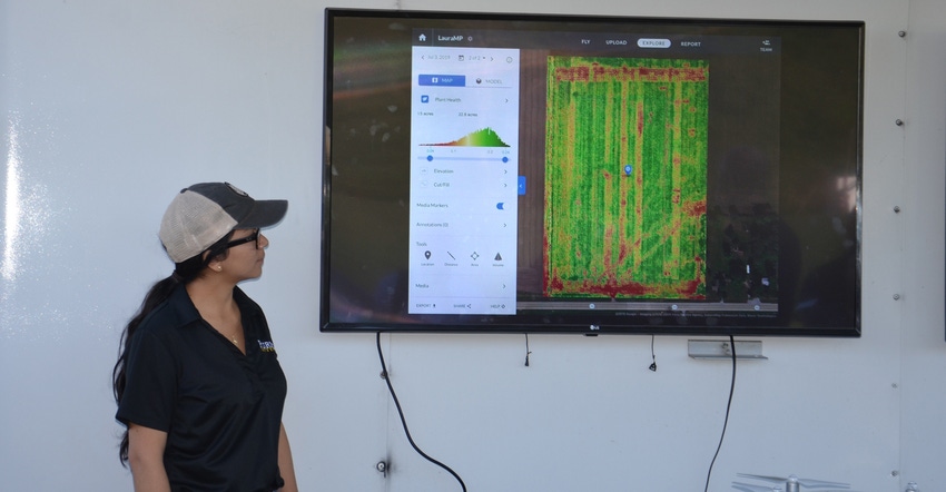 Ana Morales watches a video screen displaying images from a drone