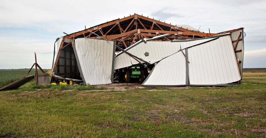 A John Deere sits under a collapsed building following a derecho storm on Aug. 10, 2020, near Franklin Grove, Illinois. The s