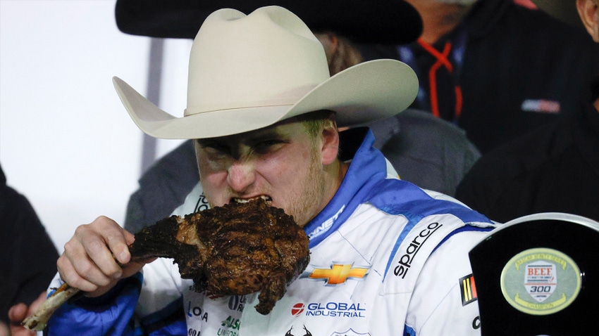 Man in cowboy hat eating tomahawk steak