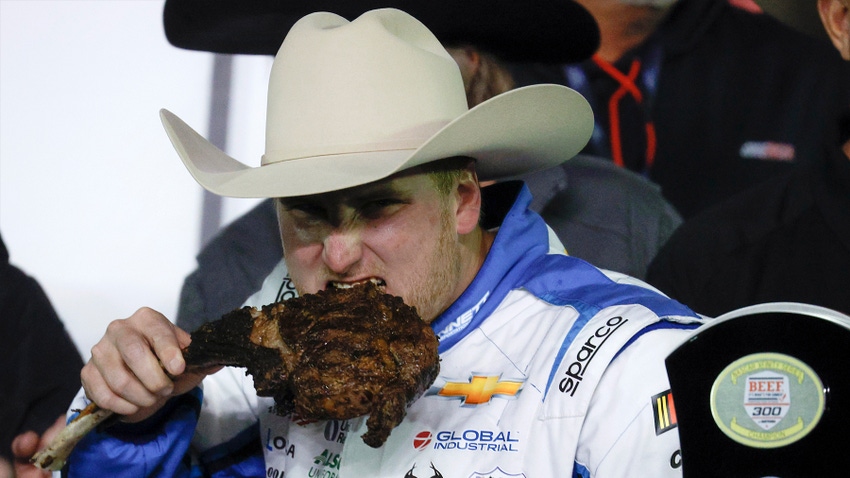 Man in cowboy hat eating tomahawk steak Man in cowboy hat eating tomahawk steak