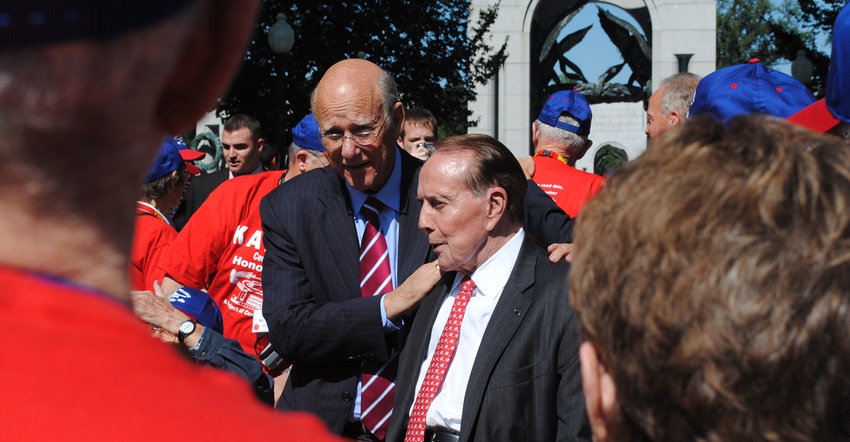 Sen. Pat Roberts puts his hands on the shoulders of former Sen. Bob Dole during a recent honor flight ceremony in Washington.
