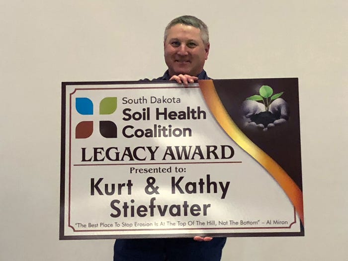 Kurt Stiefvater, Salem, S.D., displays Legacy Award sign presented by South Dakota Soil Health Coalition