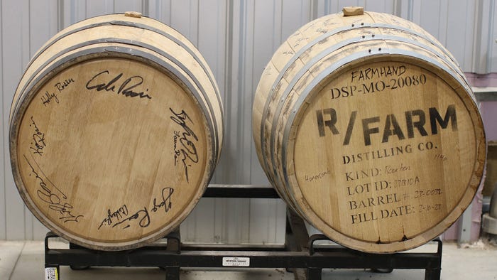Barrels reclined on their sides showing the bottom with signatures and a logo