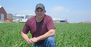  Greg Keller kneels in a field of twin row cereal rye on his farm near Monroe. 