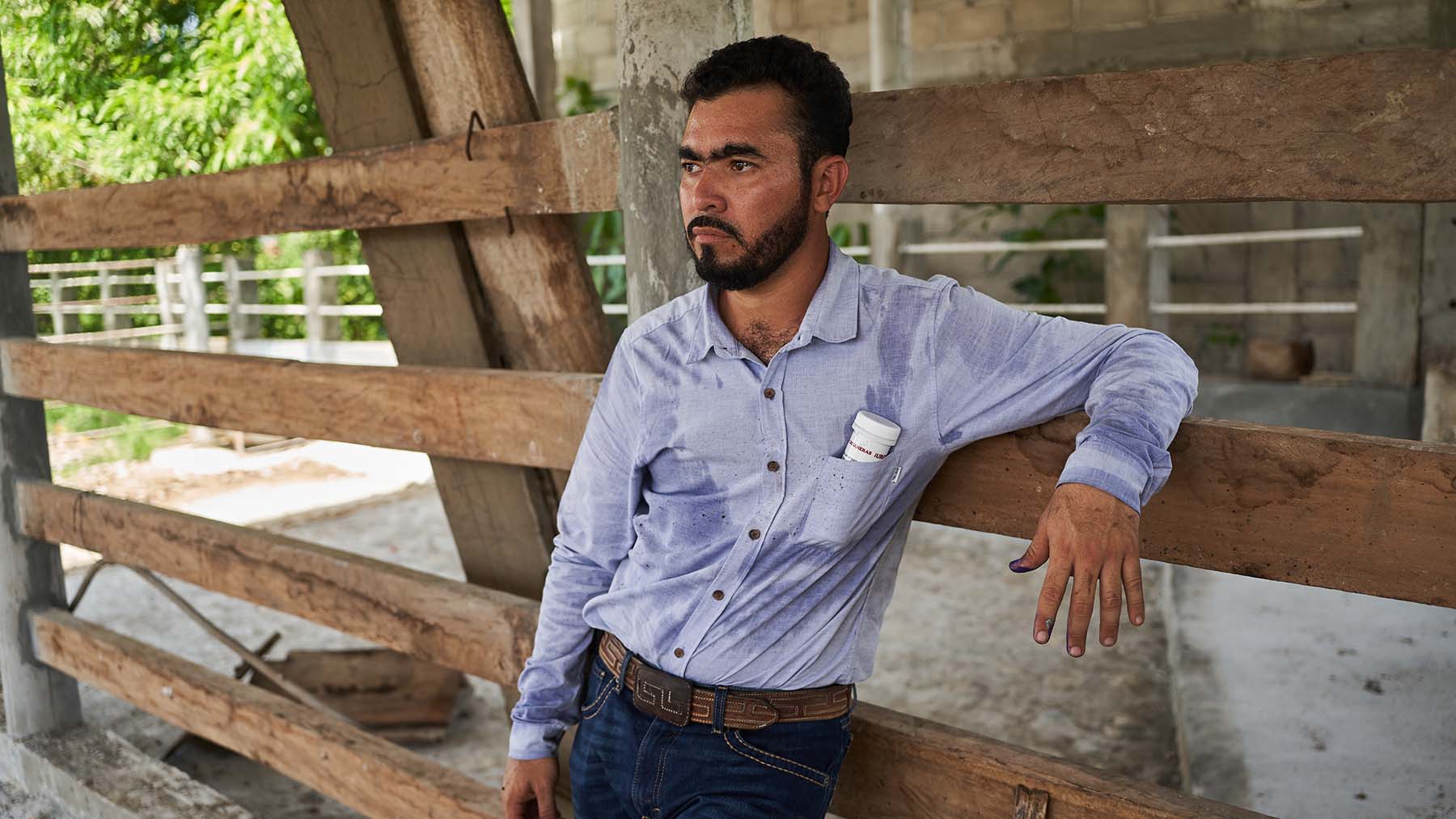 Mexican rancher leaning on fence