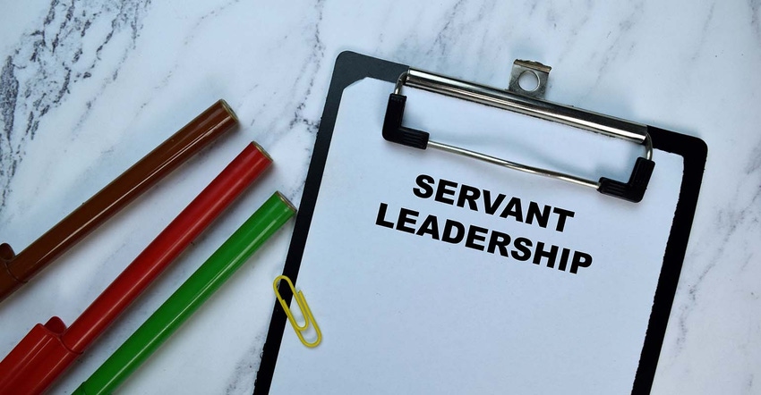 clipboard with servant leadership in text.