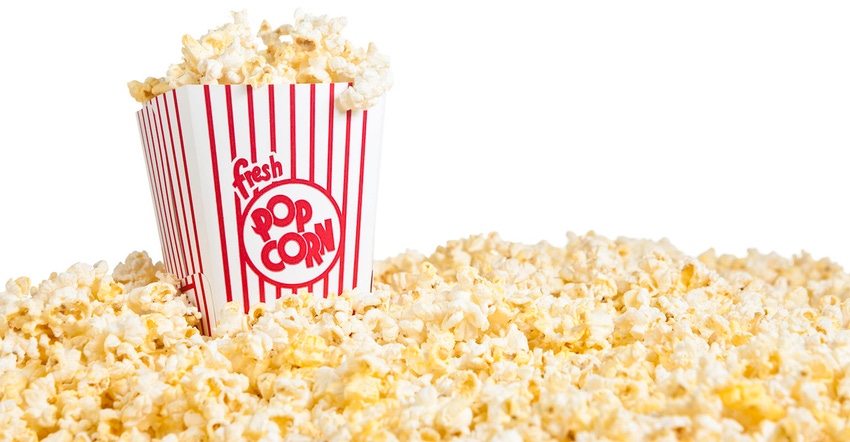 Popcorn filling bottom of frame with box of popcorn on left side of frame. Popcorn filling bottom of frame with box of popcorn on left side of frame.