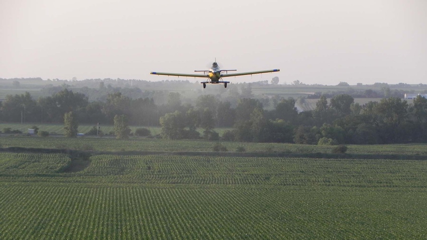 Plane crop dusting corn field