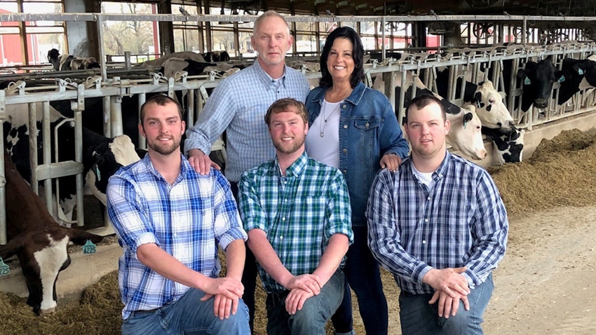 Roger and Tammy Weiland with sons Brady, Brett and Bryce, and dairy cows in the background