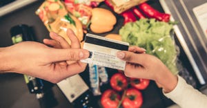 hands exchanged credit card at grocery store checkout register