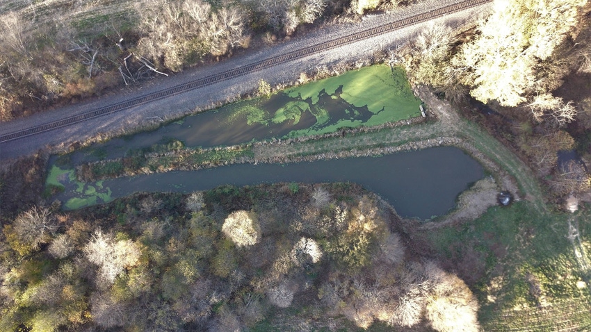  An aerial view of a small body of water near a railroad track