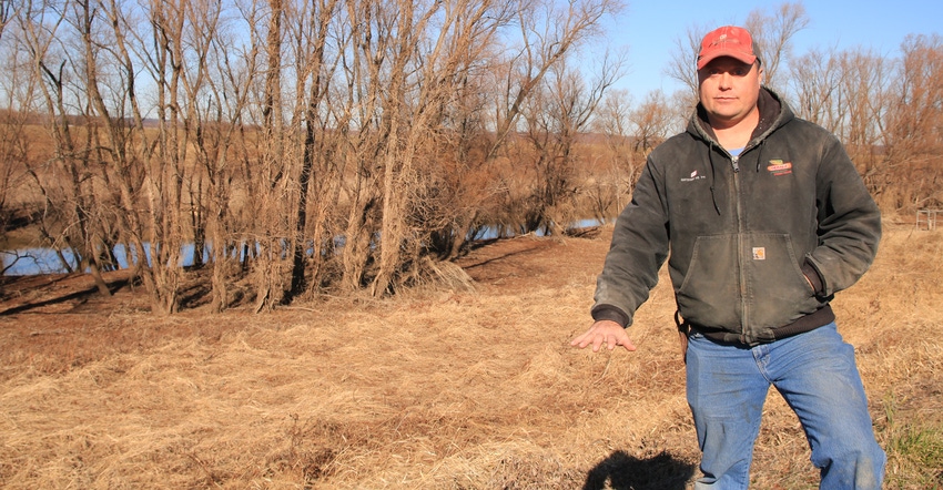 Garrett Hawkins shows how high water got on other side of levee that borders his Valmeyer, Ill., farm
