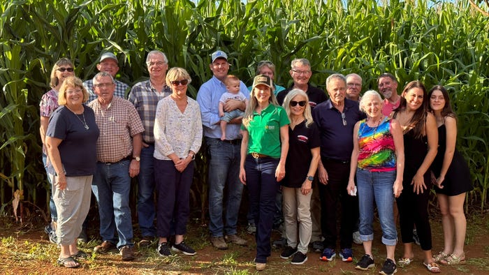 Group of travelers on the Brazil Farmland Tour posed in front of corn field