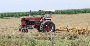 teenage boy on tractor in field