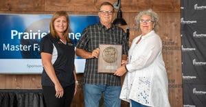 Holly Spangler presents Paul Taylor and his wife Barb the Master Farmer award