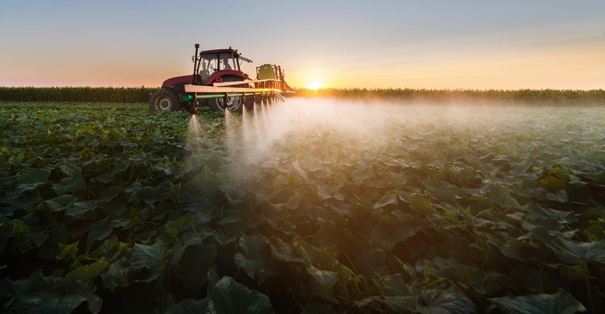 tractor spraying soybean plants