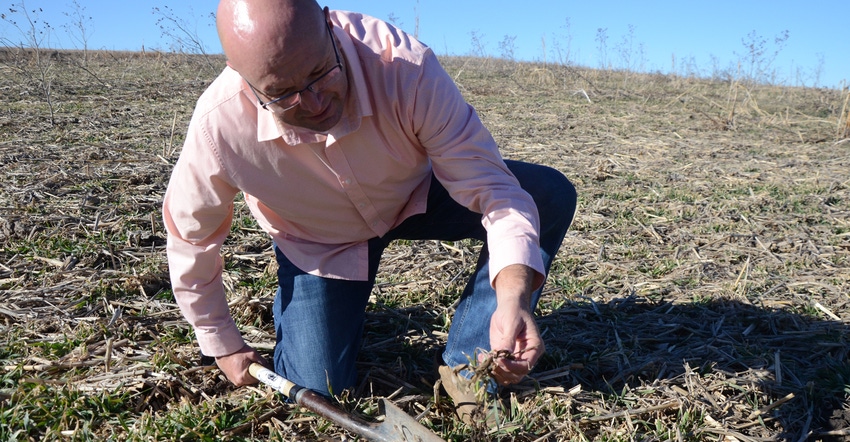 Del Ficke digs up a spadeful of soil on one of the fields on his farm west of Lincoln