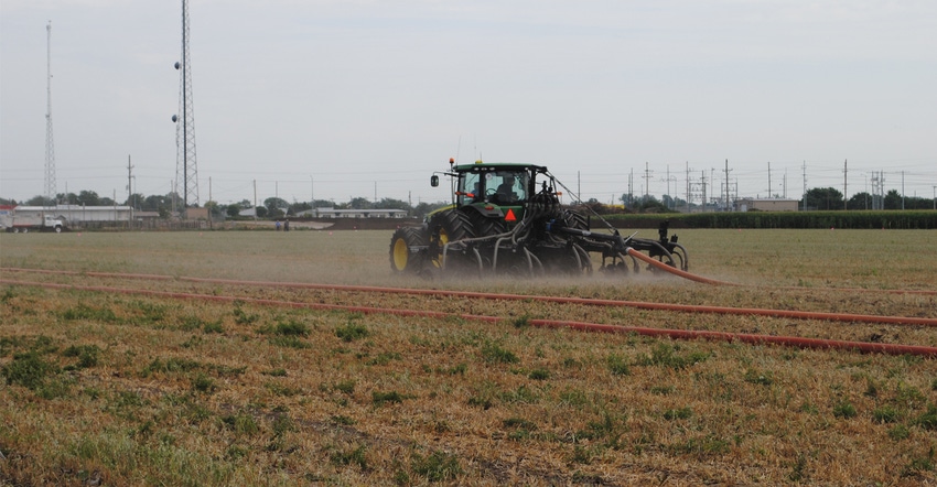 manure being applied by sprayer in field