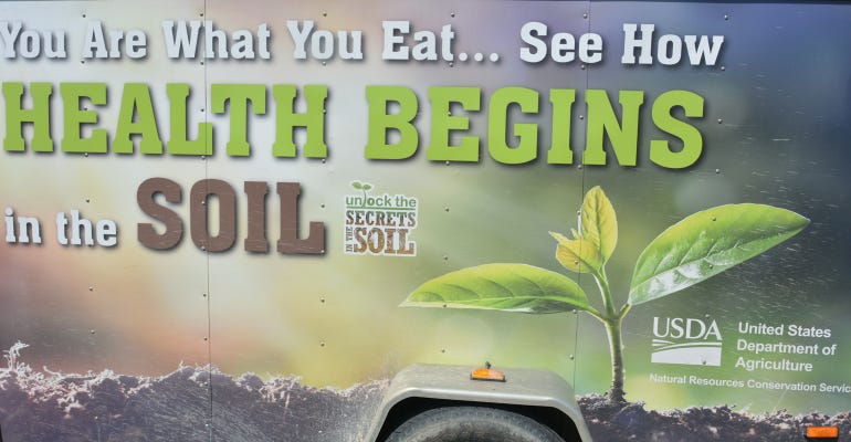mural on the side of a Natural Resources Conservation Service van with soybean   plant emerging out of soil